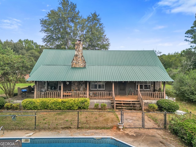 back of house with a pool side deck and a patio