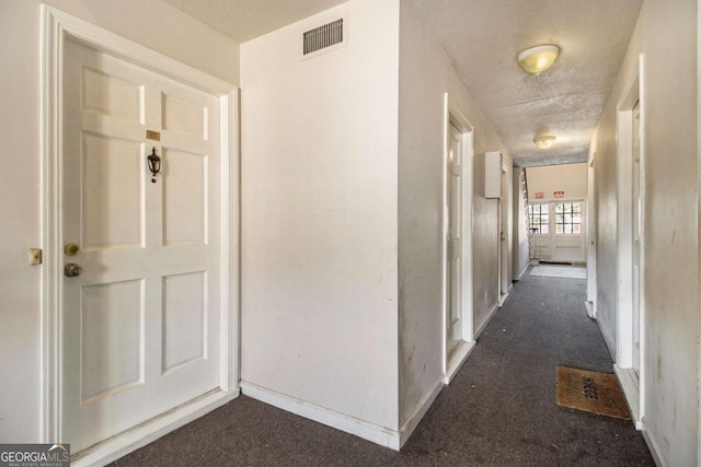 113 Rue Fontaine Unit 113, Lithonia, GA 30038 - hallway featuring dark carpet, a textured ceiling, and baseboards