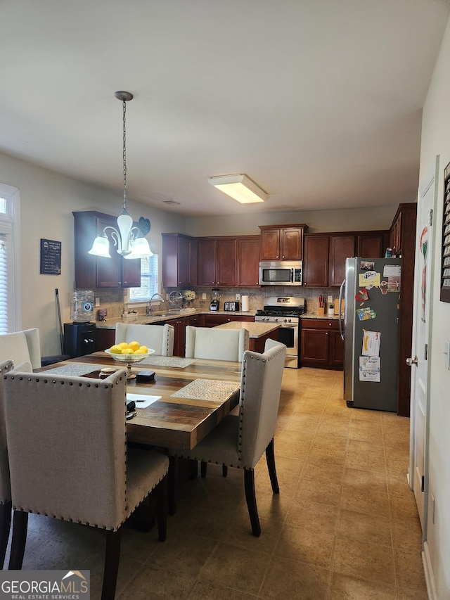 dining space with sink, light tile patterned floors, and an inviting chandelier