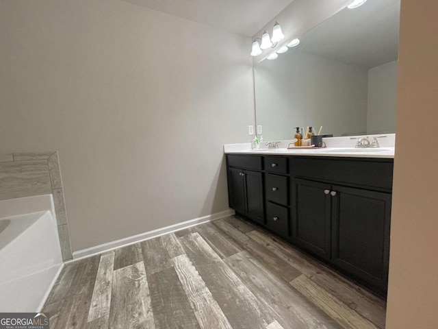 bathroom with wood-type flooring, a bathtub, and vanity