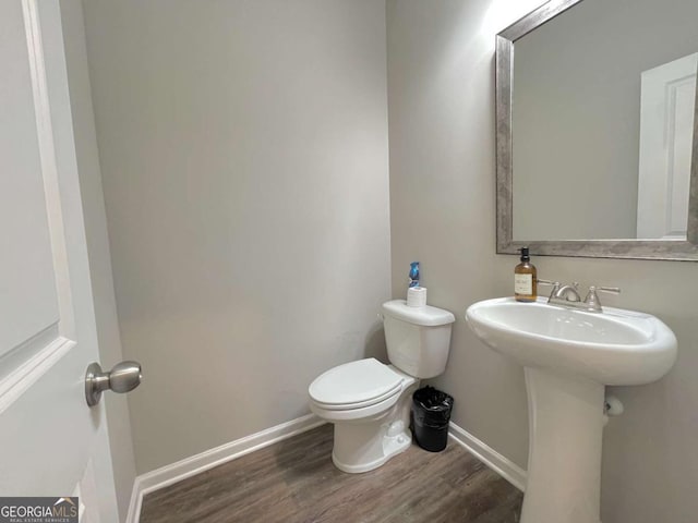 bathroom with toilet, hardwood / wood-style flooring, and sink