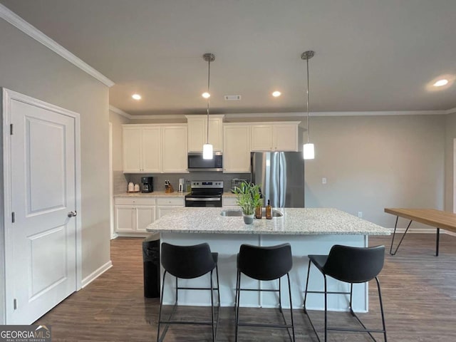 kitchen featuring a center island with sink, stainless steel appliances, white cabinets, and decorative light fixtures