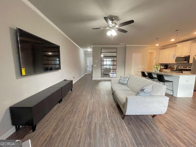 living room with ceiling fan, ornamental molding, and hardwood / wood-style floors