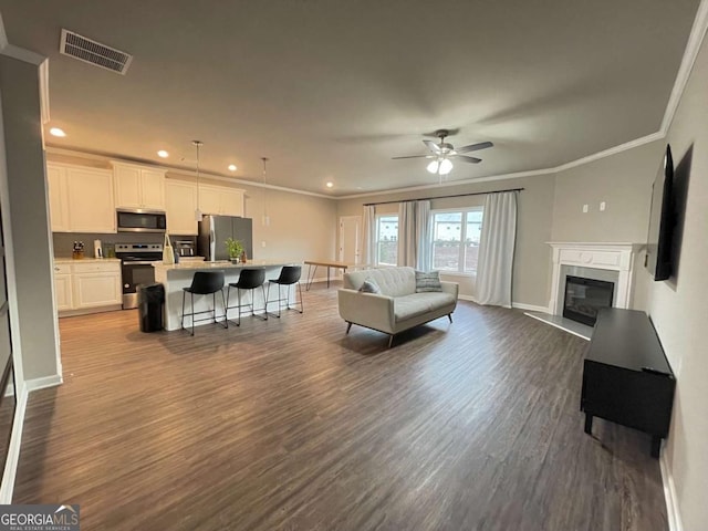 living room featuring ceiling fan, dark hardwood / wood-style floors, and ornamental molding