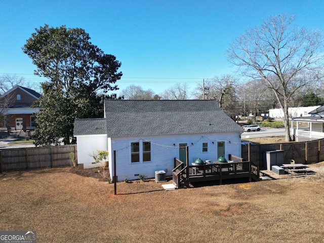 back of house featuring a deck, cooling unit, and a lawn