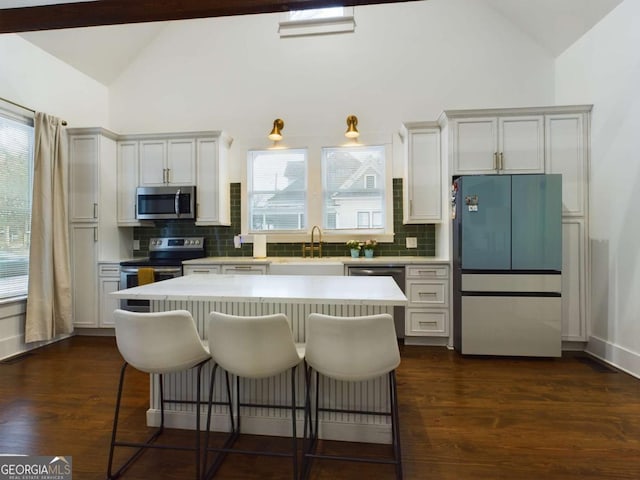 kitchen featuring white cabinetry, appliances with stainless steel finishes, and tasteful backsplash