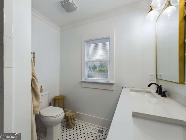 bathroom featuring toilet, vanity, and crown molding