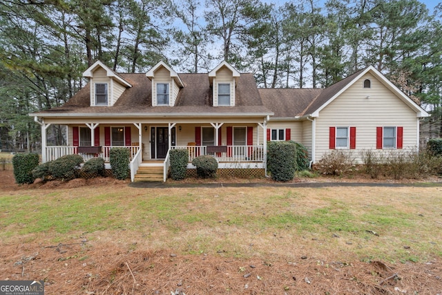 cape cod home featuring a front lawn and a porch