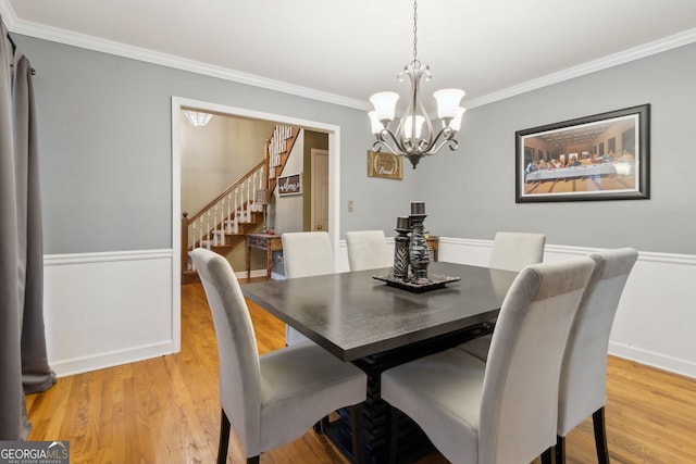 dining room featuring crown molding, a chandelier, and light hardwood / wood-style floors