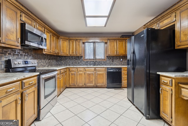 kitchen featuring black appliances, light tile patterned floors, sink, and tasteful backsplash