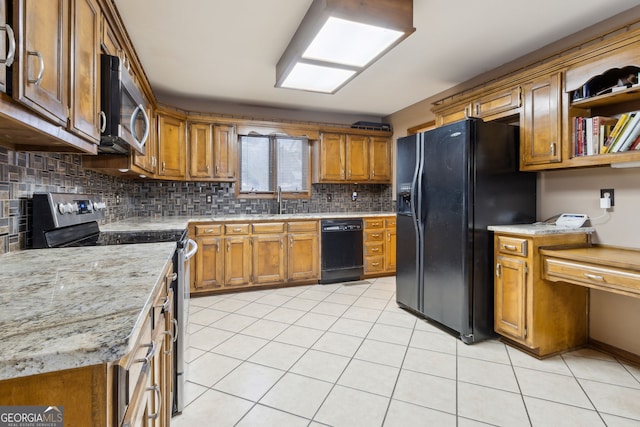 kitchen featuring light tile patterned flooring, sink, black appliances, and tasteful backsplash