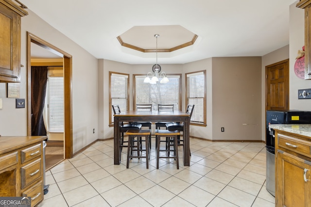 dining room featuring crown molding, light tile patterned floors, a raised ceiling, and a notable chandelier