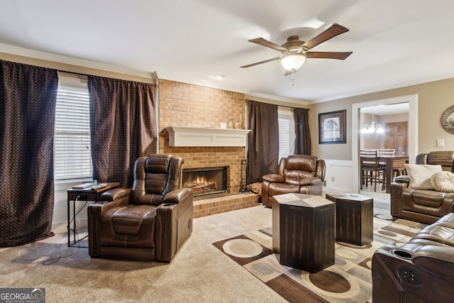 carpeted living room with crown molding, a fireplace, and ceiling fan with notable chandelier