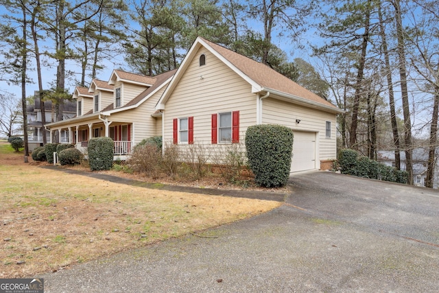 view of side of home with a lawn, a porch, and a garage