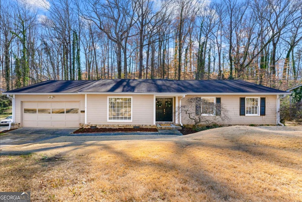 single story home with a garage and a front lawn