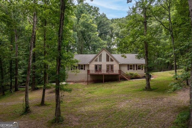 back of property with a lawn and a deck