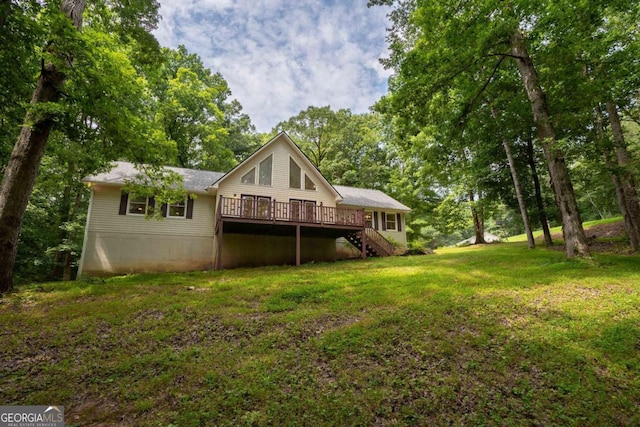 back of house featuring a wooden deck and a lawn