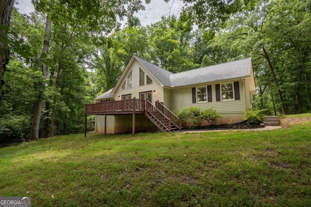 back of house with a wooden deck and a lawn