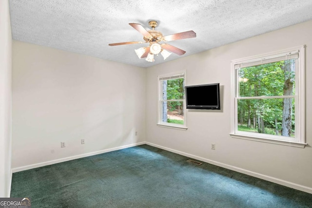 carpeted empty room featuring ceiling fan and a textured ceiling