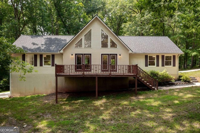 rear view of property featuring a wooden deck, a yard, and french doors