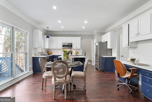 kitchen with hanging light fixtures, white cabinetry, appliances with stainless steel finishes, and blue cabinetry