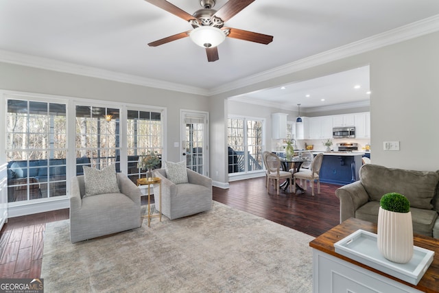 living room featuring wood-type flooring, ceiling fan, and crown molding