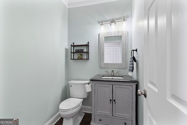 bathroom with vanity, hardwood / wood-style flooring, ornamental molding, and toilet