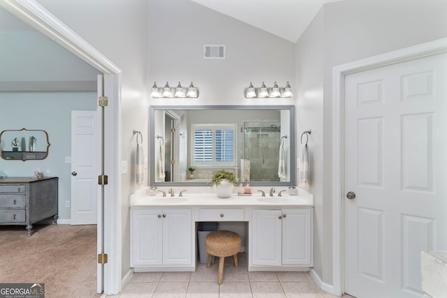 bathroom featuring vanity, vaulted ceiling, tile patterned floors, and a shower with shower door