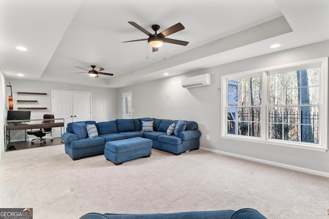 carpeted living room featuring a wall mounted AC, ceiling fan, and a tray ceiling