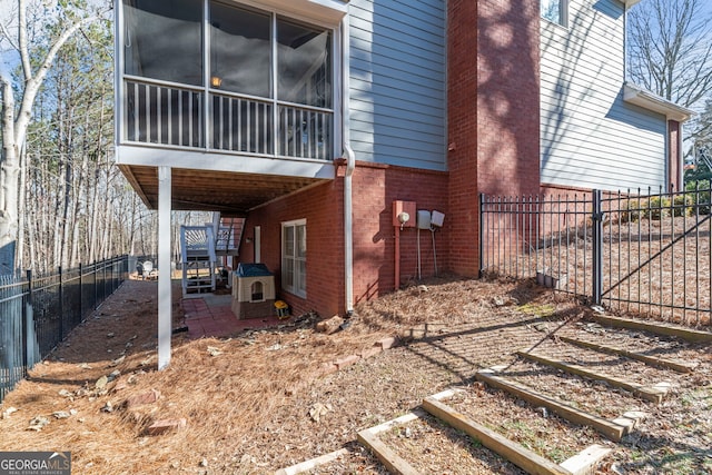 view of side of home featuring a patio and a sunroom