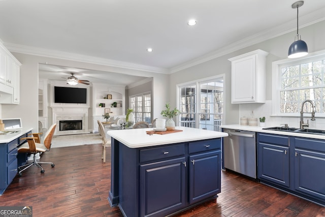 kitchen with white cabinetry, stainless steel dishwasher, blue cabinets, and sink