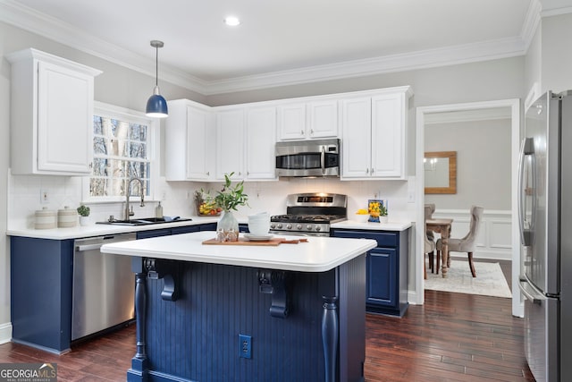 kitchen with appliances with stainless steel finishes, pendant lighting, sink, white cabinets, and dark hardwood / wood-style flooring