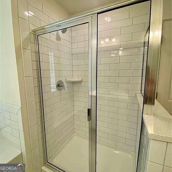 bathroom featuring a shower with shower door