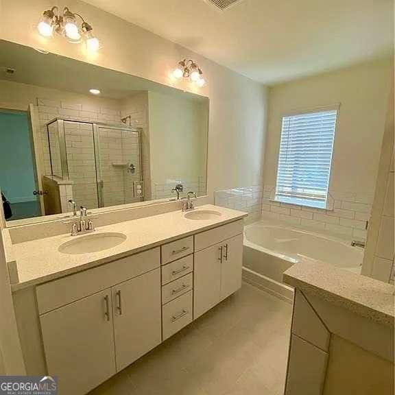 bathroom featuring tile patterned floors, vanity, and independent shower and bath