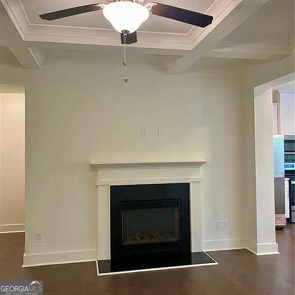 room details featuring coffered ceiling, ceiling fan, stove, ornamental molding, and beam ceiling