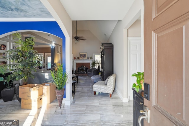 entryway featuring ceiling fan and a brick fireplace