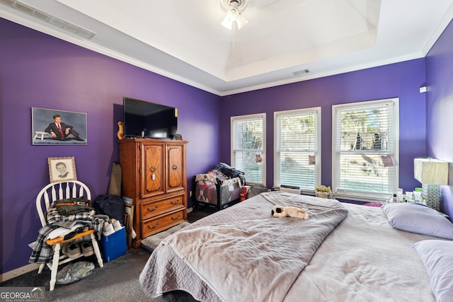 bedroom featuring ceiling fan, carpet flooring, ornamental molding, and a raised ceiling