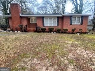 single story home featuring a front lawn