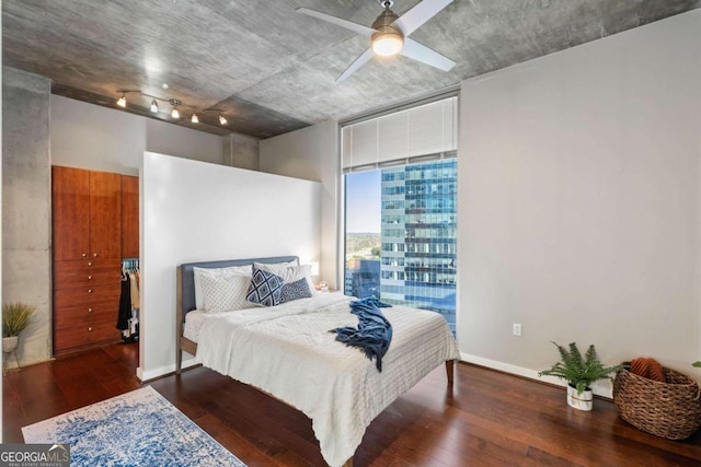 bedroom featuring ceiling fan, a wall of windows, and dark hardwood / wood-style floors