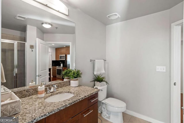 bathroom featuring tile patterned floors, a shower with door, toilet, and vanity