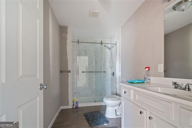 bathroom with hardwood / wood-style flooring, an enclosed shower, vanity, and toilet