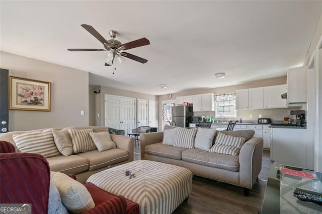 living room with ceiling fan and dark hardwood / wood-style flooring