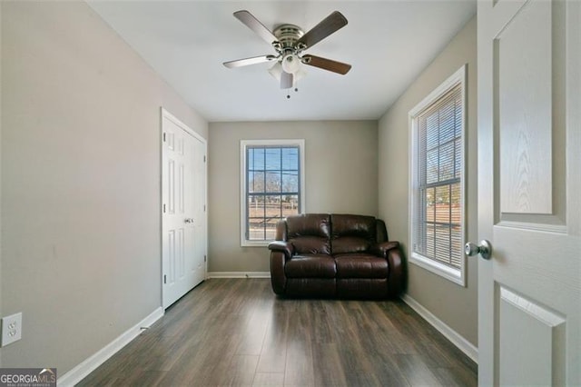 living area with ceiling fan and dark hardwood / wood-style flooring