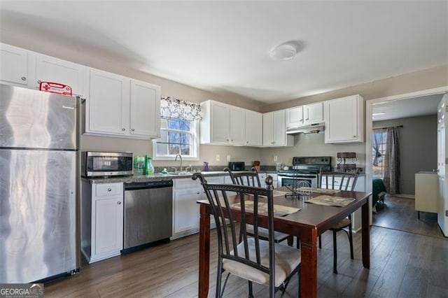 kitchen with appliances with stainless steel finishes, sink, white cabinetry, and dark hardwood / wood-style floors