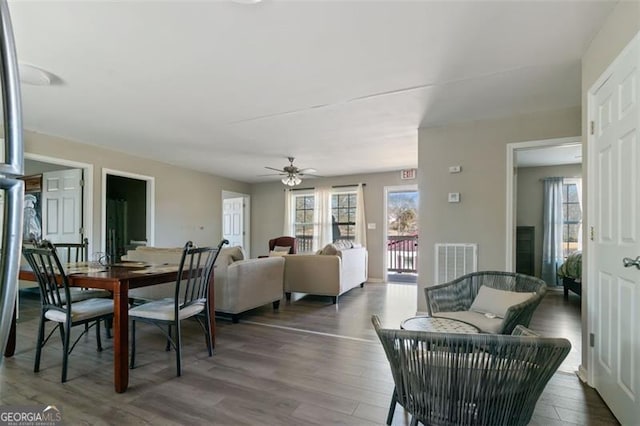 dining space with ceiling fan and dark hardwood / wood-style flooring