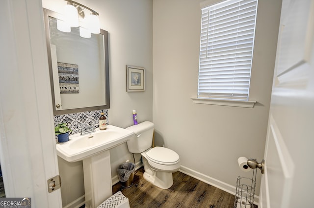 bathroom with toilet, backsplash, wood-type flooring, and sink