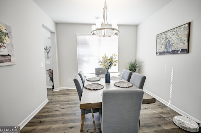 dining area with dark hardwood / wood-style floors and a chandelier