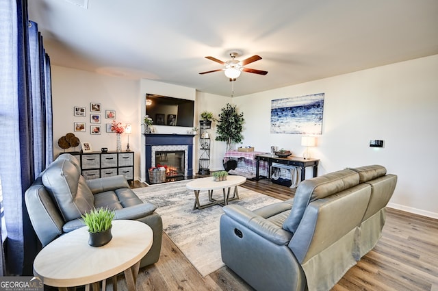 living room featuring ceiling fan and light hardwood / wood-style floors