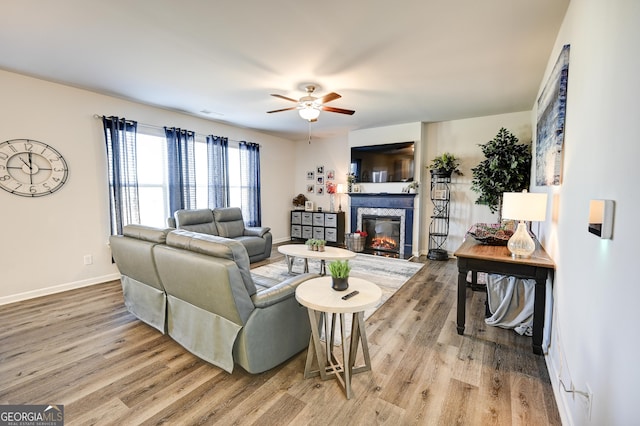 living room featuring ceiling fan and light hardwood / wood-style flooring