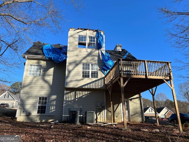 rear view of house featuring cooling unit and a wooden deck